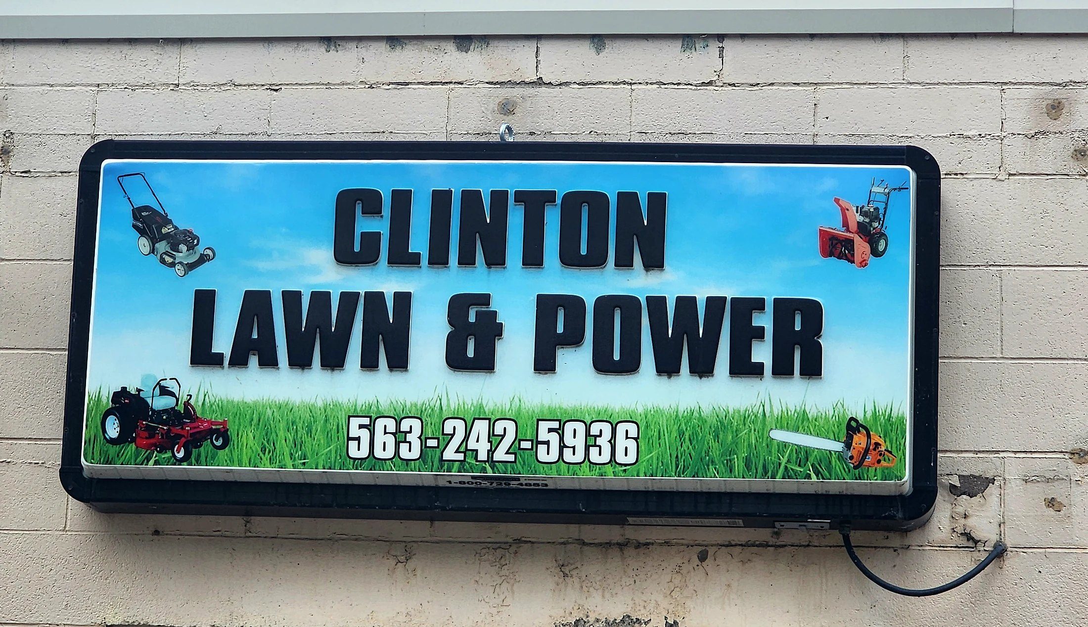 Clinton Lawn & Power lighted cabinet sign installed on the storefront