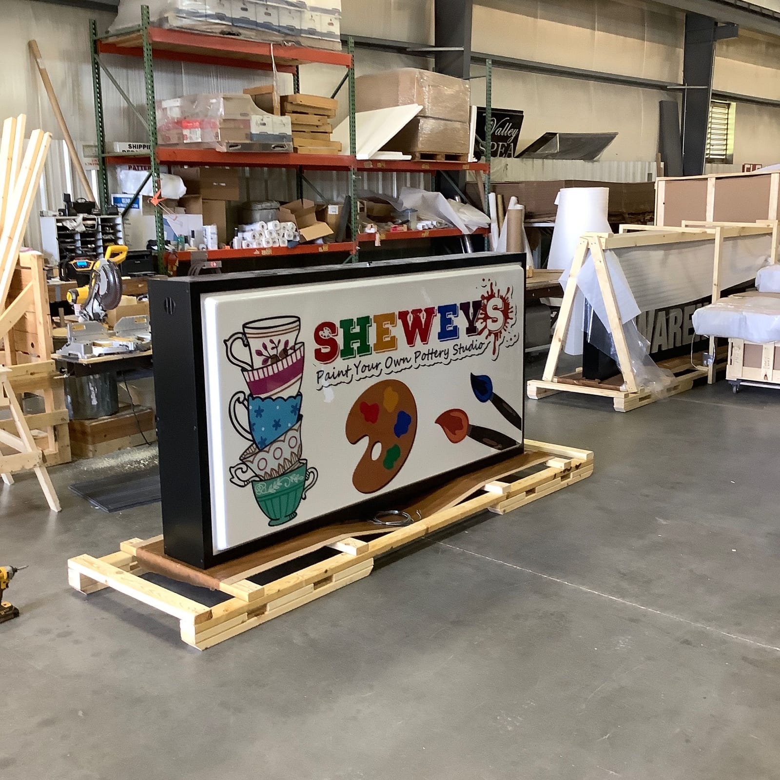 Illuminated Shewey's pottery studio sign being prepared during production